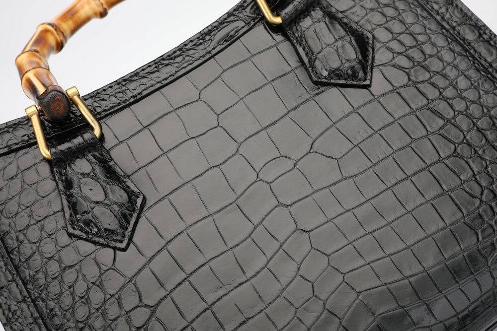 Rossie Viren crocodile leather micro top handle cross body handbag with a sleek, structured design and adjustable strap.