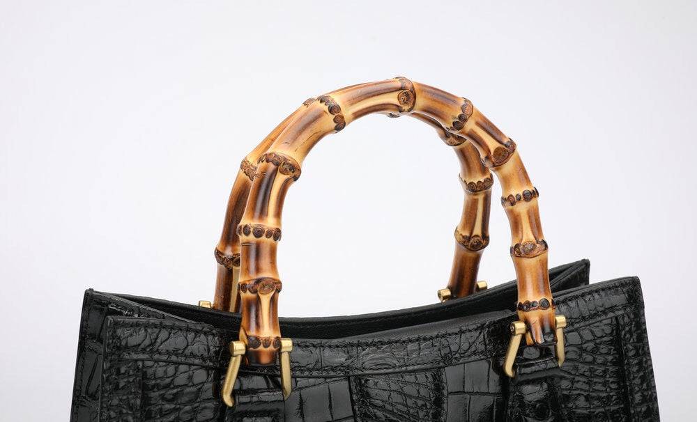 Rossie Viren crocodile leather micro top handle cross body bag with large design and sleek, textured crocodile pattern.
