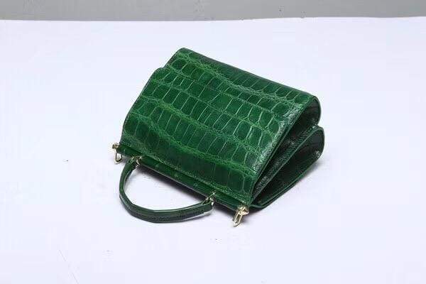 Dark green crocodile leather top handle handbag by Rossie Viren with elegant design and sturdy handle.