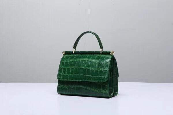 Dark green crocodile leather top handle handbag by Rossie Viren, featuring a sleek, structured design with a sturdy handle.