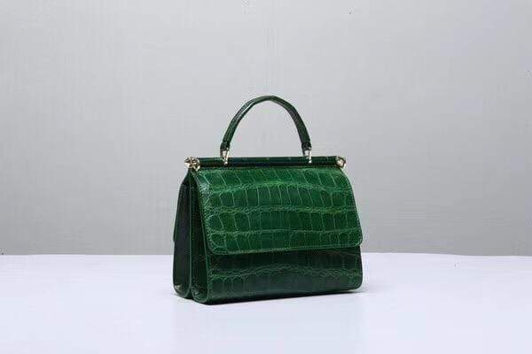 Dark green crocodile leather top handle handbag by Rossie Viren, featuring a sleek, structured design with a sturdy top handle.
