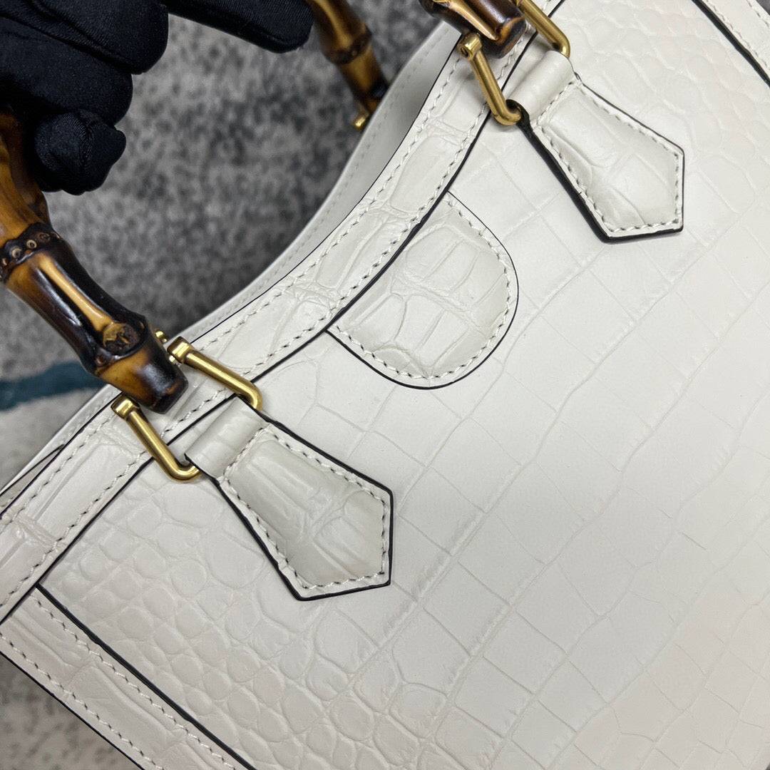 White crocodile skin leather crossbody handbag with bamboo handle by Rossie Viren, featuring a sleek shoulder strap and textured finish.