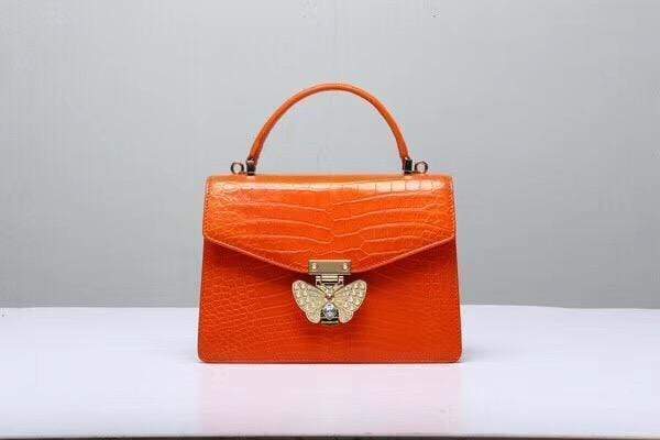 Genuine Siamese crocodile leather orange cross body handbag with top handle by Rossie Viren.