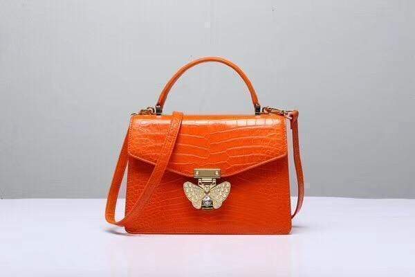 Genuine Siamese crocodile leather top handle crossbody bag in vibrant orange, by Rossie Viren, featuring a sleek, textured design.