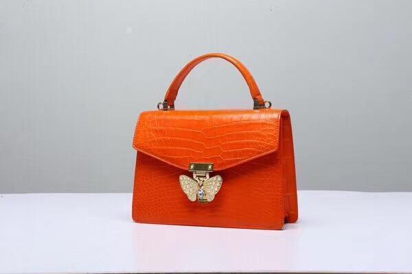 Genuine Siamese crocodile leather top handle crossbody bag in vibrant orange by Rossie Viren.