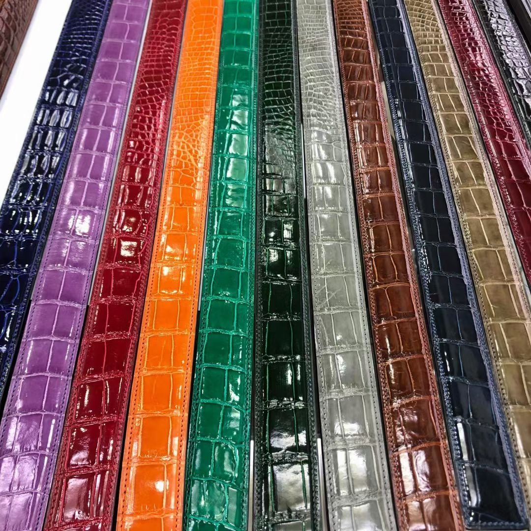 Shiny Nile crocodile skin leather belt by Rossie Viren featuring a sleek, polished finish and a classic buckle design.