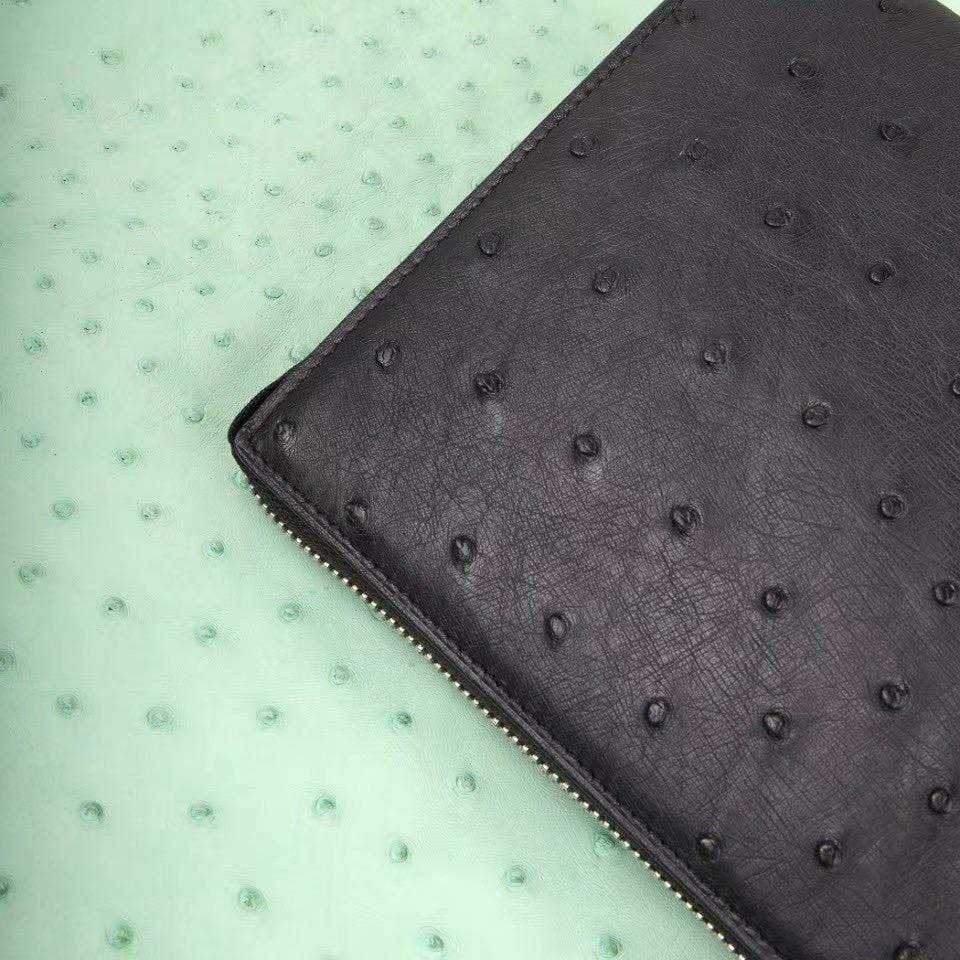 Mens Rossie Viren genuine ostrich leather clutch bag with zipper, wrist handle, and card wallet for stylish carrying.