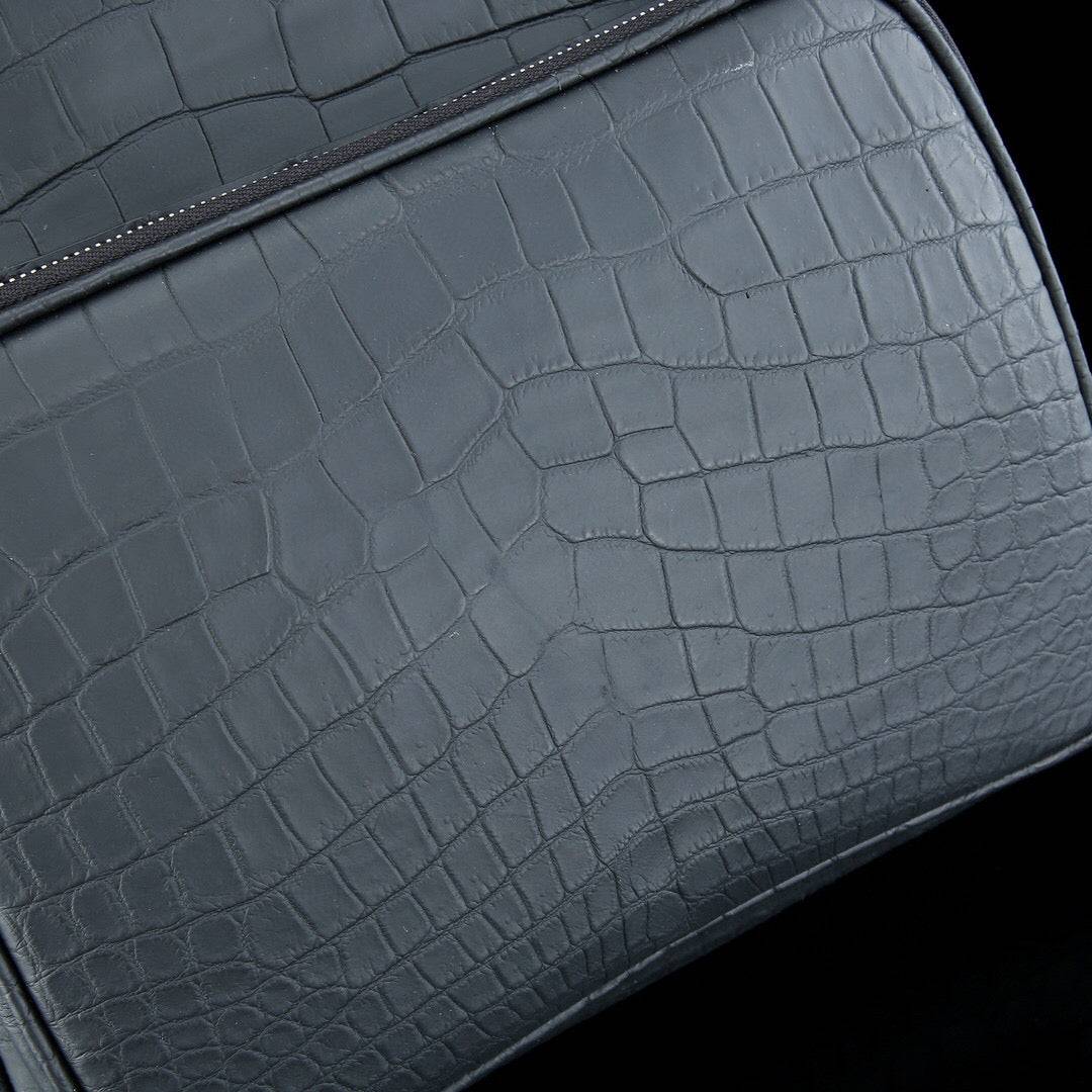 Large matte black crocodile leather backpack by Rossie Viren with sturdy straps and textured crocodile pattern for men.