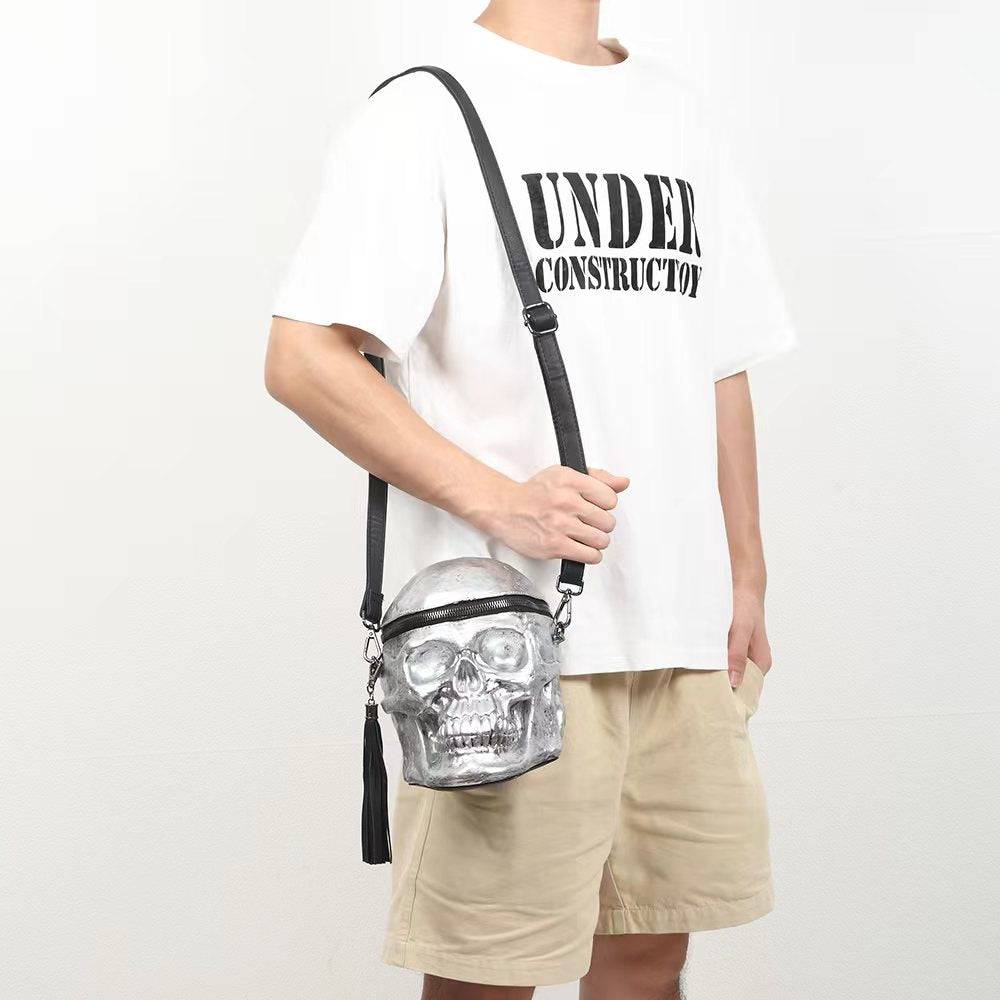 Silver 3D skull cross body handle bag by Rossie Viren with mini handle and shoulder strap, featuring a detailed skull design.