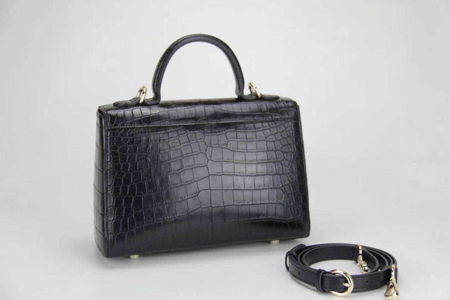 Woman holding Rossie Viren crocodile leather messenger handbag with crossbody strap and top handle, stylish women's leather bag.