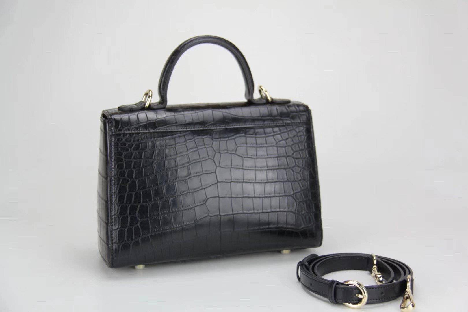 Woman holding Rossie Viren crocodile leather messenger handbag with crossbody strap and top handle, stylish women's leather bag.