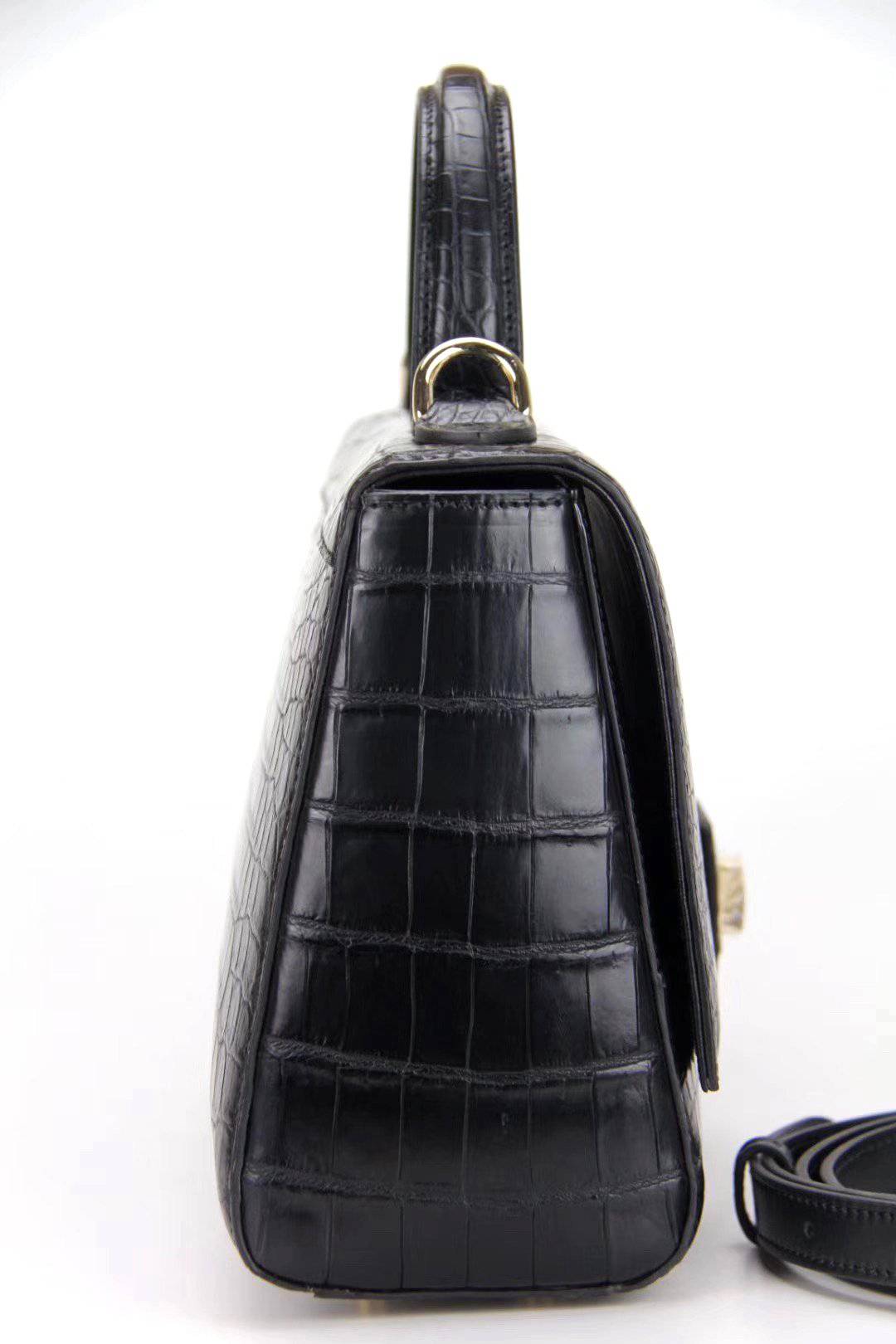 Women's crocodile leather messenger handbag by Rossie Viren with cross-body strap and top handle, showcasing textured crocodile pattern.