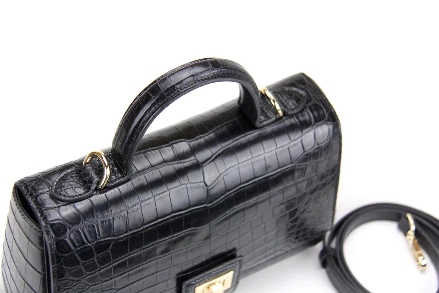 Women's crocodile leather messenger handbag with crossbody strap and top handle by Rossie Viren, showing textured crocodile pattern.