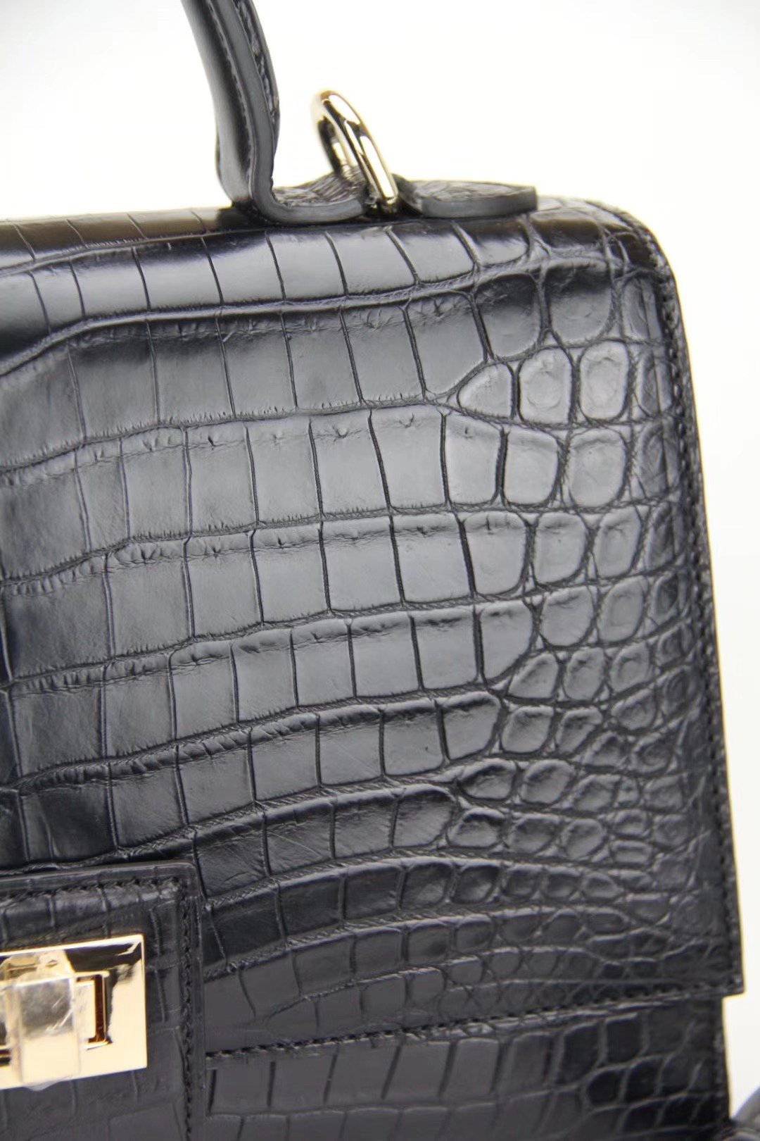 Women's crocodile leather messenger handbag with crossbody strap and top handle by Rossie Viren, featuring a sleek, structured design.