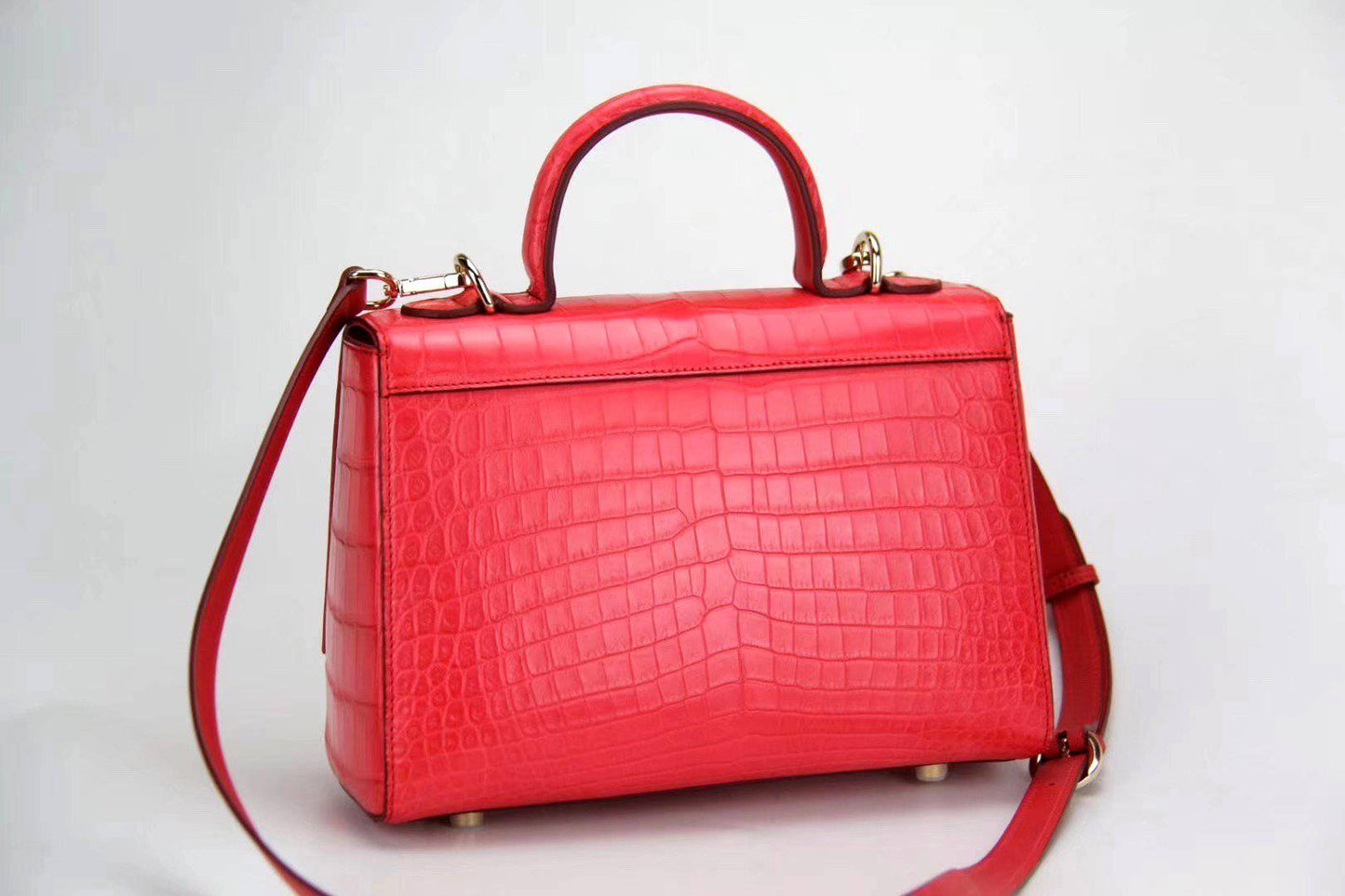Women’s crocodile leather messenger handbag with crossbody strap and top handle by Rossie Viren, featuring a textured crocodile pattern.