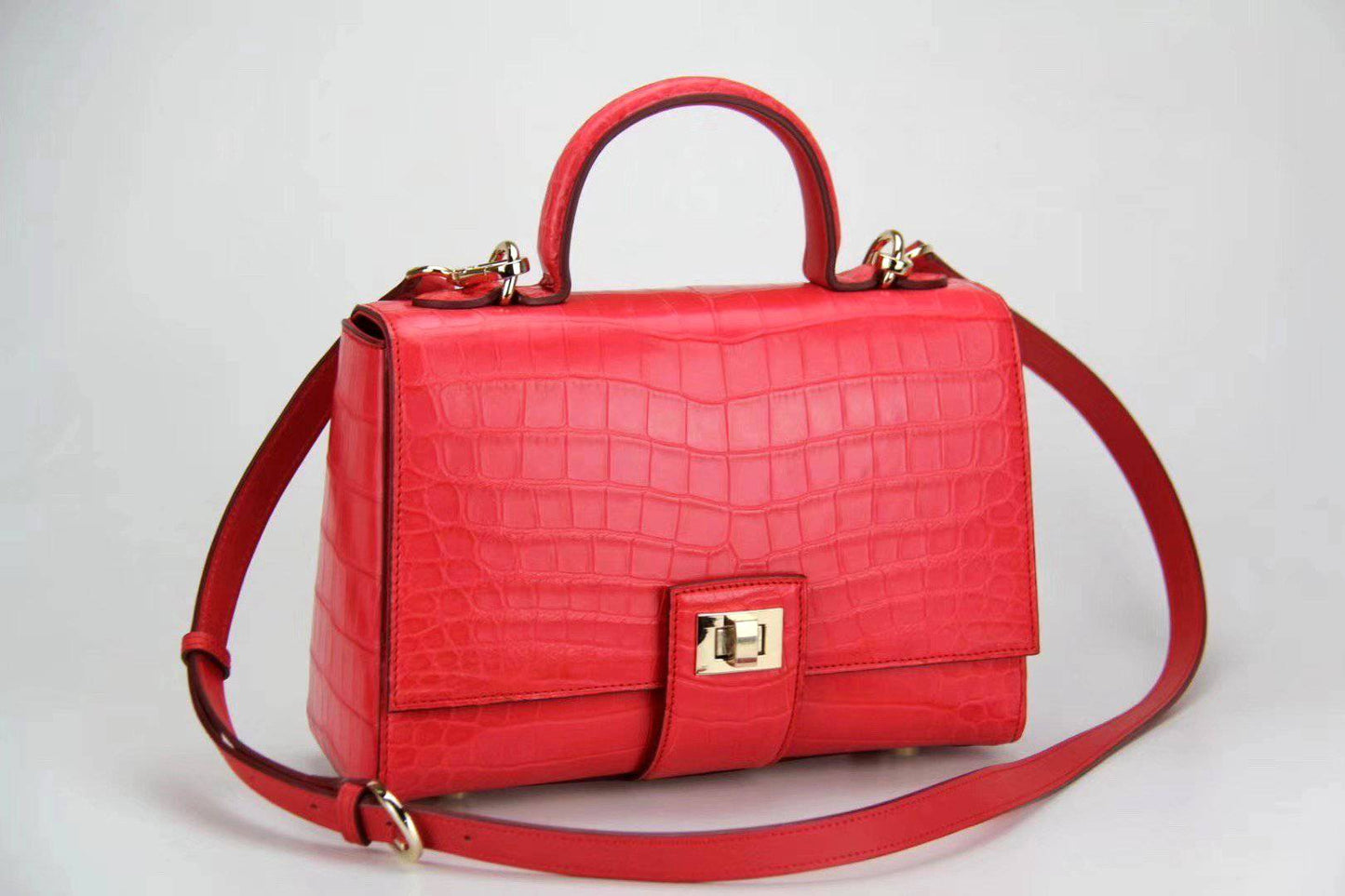 Women's crocodile leather messenger handbag with crossbody strap and top handle by Rossie Viren. Elegant and stylish accessory.