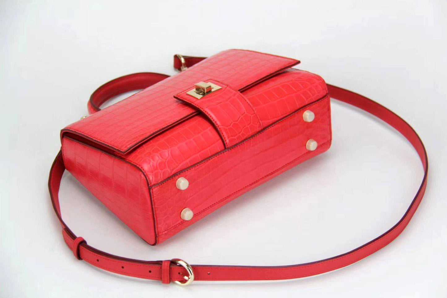 Women's crocodile leather messenger handbag with crossbody strap and top handle by Rossie Viren, featuring a sleek, textured design.