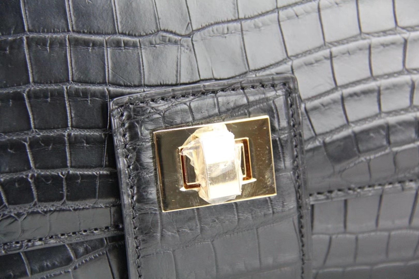 Women’s crocodile leather messenger handbag by Rossie Viren with cross-body strap and top handle, stylish and textured leather design.