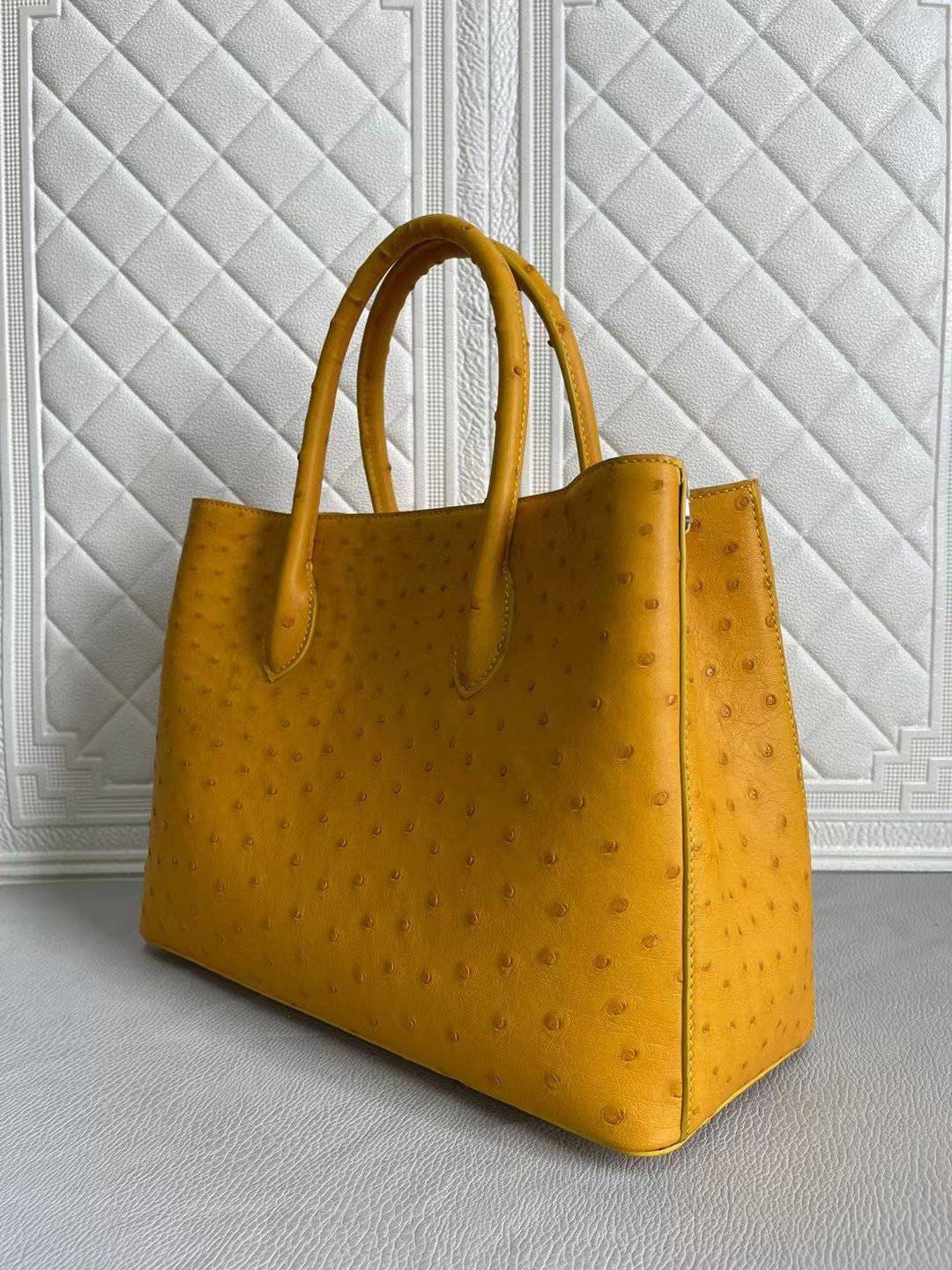Rossie Viren women's ostrich leather handbag with top handle and crossbody strap in coral blue and yellow, 33cm.